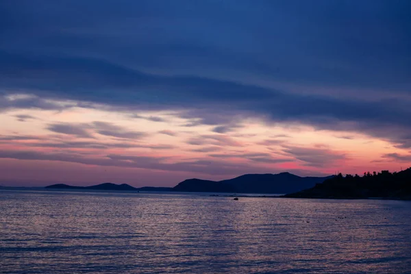 Silhueta ilha rochosa no mar durante o pôr do sol roxo . — Fotografia de Stock