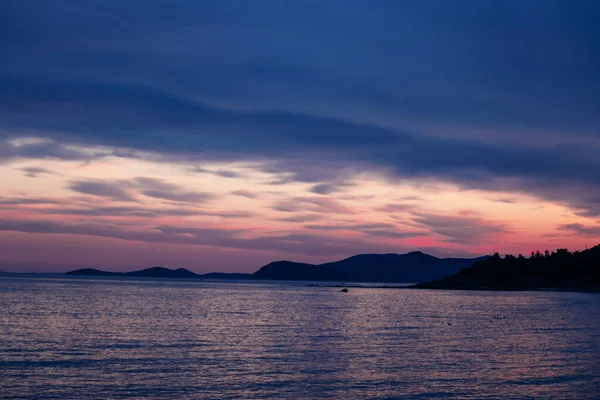 Silueta de isla rocosa en el mar durante el atardecer púrpura . —  Fotos de Stock