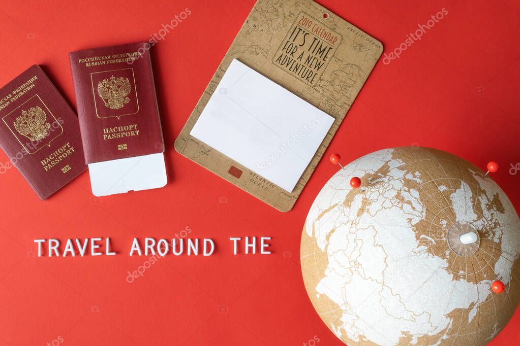 Cork globe with red pins, blank mockup calendar and passports with ticket and text 