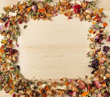 Kuru otlardan, çiçeklerden, çaydan ve köşedeki tahta kürekten yapılmış çerçeve. Tahta yüzey, düz yatış, model konsepti. Lüks çay..