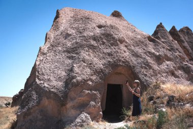 Eski mağaranın fotoğrafını çeken kadın.