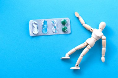 Mavi arkaplanda tabletleri olan ahşap bir heykel