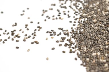 Beyaz arka planda izole edilmiş kuru chia tohumları. Seçici odak, boşluğu kopyala..