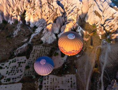Türkiye 'nin Kapadokya Vadisi üzerinde uçan iki sıcak hava balonu manzarasının üzerinde.