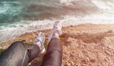 Uçurumun kenarında oturan bir kadın