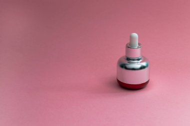 Pipette şişe bakuchiol özü pembe arka planda. Uzayı kopyala - Retinol alternatif konsepti..
