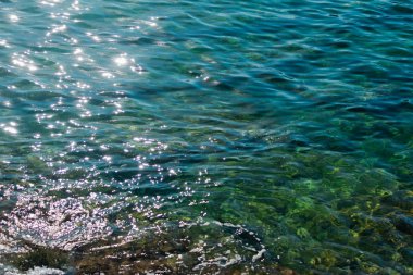 Sol tarafında parlak güneş yolu olan deniz yüzeyi