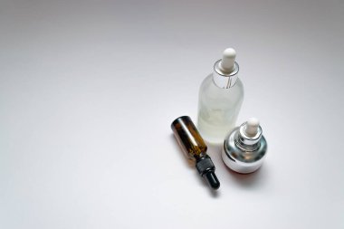 Beyaz arka planda üç adet lüks kozmetik ürünü ve yazı için yer var. Bakuchiol kavramı.