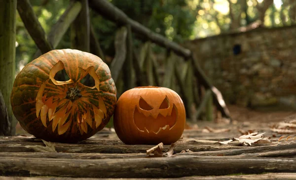 Carved pumpkins on bridge in forest, Halloween concept.
