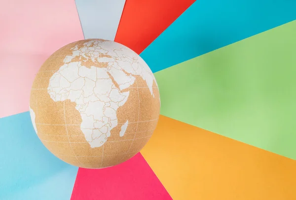 软木塞全球与非洲大陆在五彩斑斓的几何背景. 复制空间，平铺。 旅行世界的概念，拯救地球的概念. — 图库照片