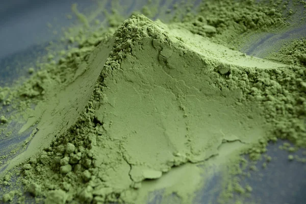 Close up pile of matcha powder on black plate. Natural matcha green tea concept. — Stock Photo, Image