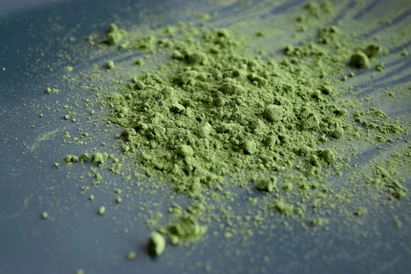 Närbild matcha pulver på svart tallrik. Naturlig matcha grönt te koncept. — Stockfoto