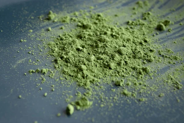 Sluit matcha poeder op zwarte plaat. Natuurlijke matcha groene thee concept. — Stockfoto