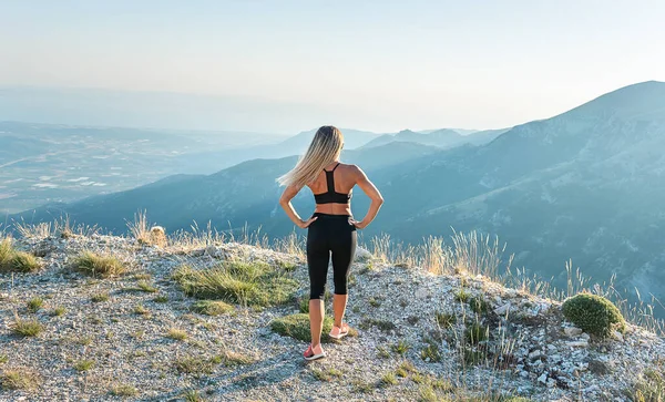 若いですブロンド女性でスポーツウェア高いで山 — ストック写真