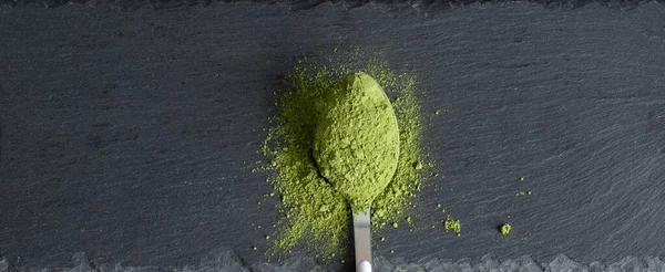 Vista aérea sobre cuchara con matcha en polvo sobre tabla de piedra. Concepto natural de suplementos superalimentarios orgánicos. Colocación plana, espacio de copia . —  Fotos de Stock