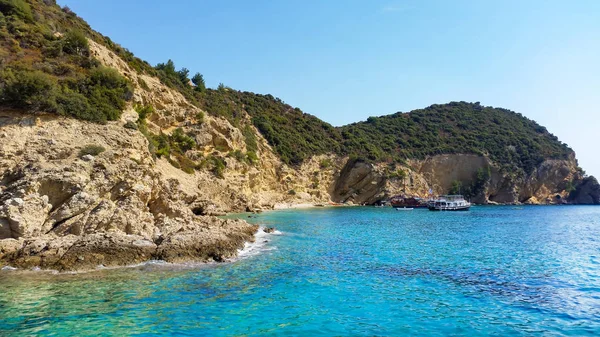 Turkuaz mavi deniz suyu ve etrafındaki kayalık kayalıklarla dolu vahşi kumsalın manzarası. Yaz mevsimi kavramı. 