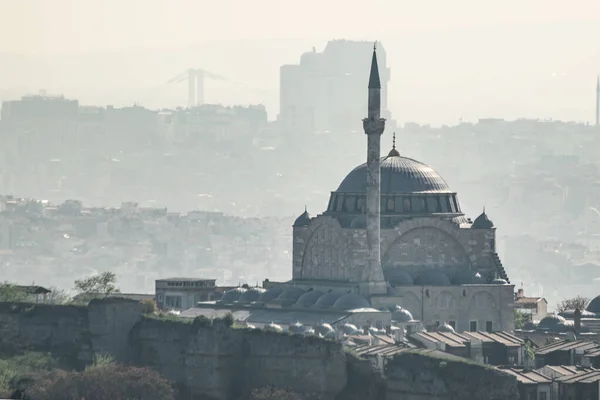 Aerial view on mosque with one minaret and ancient castle wall ruins, foggy city on background. Istanbul, Turkey. Copy space. — Stock Photo, Image