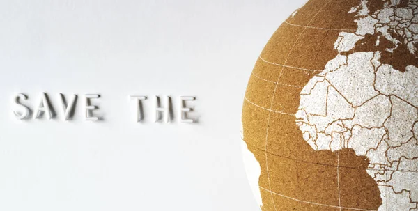 Close up cork globe with text "Save the" on the left. Save the planet Earth concept. White background, flat lay. — Stock Photo, Image