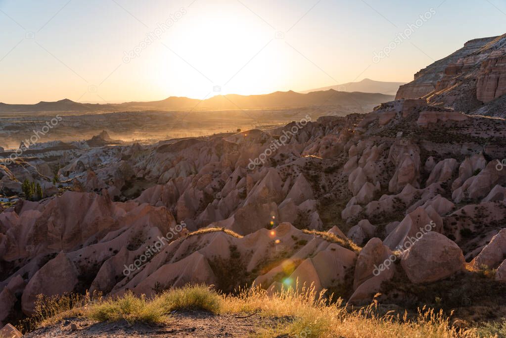 Scenic view of Red Rose Valley during sunset. Cappadocia, Turkey. Lens flare.