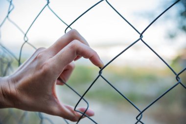 İnsan eli metalik ızgarayı tutuyor