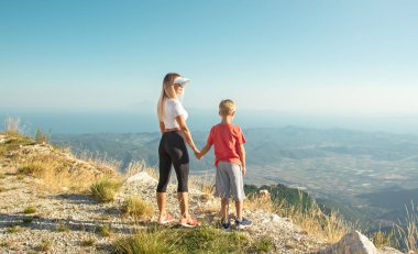 Dağlarda erkeğin elini tutan kadın.