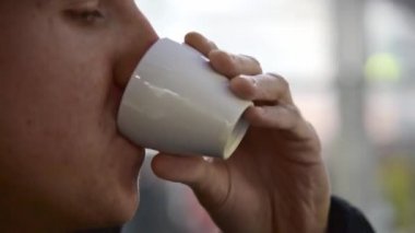 Yakın plan adam kafeteryada espresso içiyor..