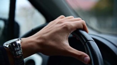 Direksiyonda kol saati olan bir adamın eliyle çekilmiş bir video..