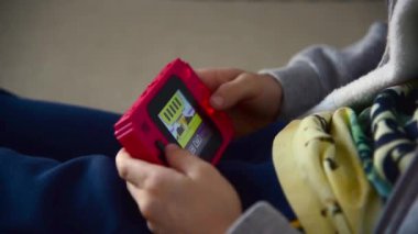 Kavala, Yunanistan - 11 / 15 / 2019: Kırmızı renkli 8-bit konsolu oynayan çocuk, 