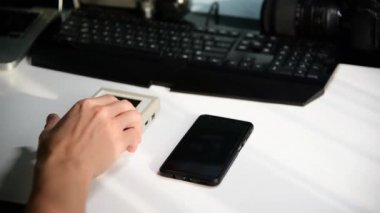Eski Nintendo Game Boy ile yeni akıllı telefon arasında seçim yapmaya çalışan bir adam. Klasik video oyunları konsepti oynanıyor.