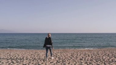 DSR kameralı kadın fotoğrafçı gün batımında boş sahilde fotoğraf çekiyor..