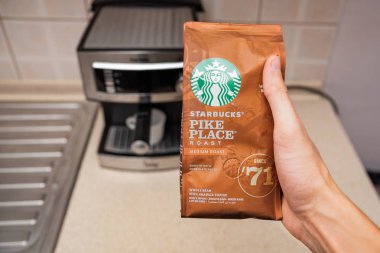 Kavala, Yunanistan - 18 Kasım 2019: Starbucks marka kahve paketi mutfakta, espresso makinesi arka planda.