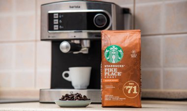Kavala, Yunanistan - 18 Kasım 2019: Mutfakta Starbucks marka kahve paketi, arka planda orta pişmiş fasulye kahve, espresso makinesi.