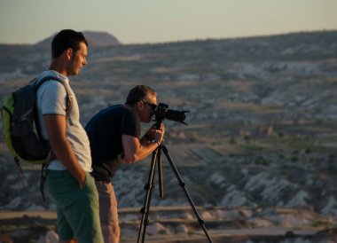 Kapadokya, Türkiye - 07.02.2019: Kapadokya 'nın popüler turizm beldesi olan Kırmızı Gül Vadisi' nde gün batımının fotoğraflarını çeken fotoğrafçılar.