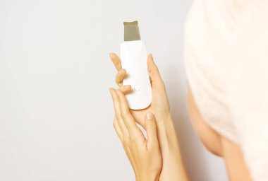 Beyaz kadının ellerinde bir güzellik aleti var. Ev konseptinde güzellik prosedürü.