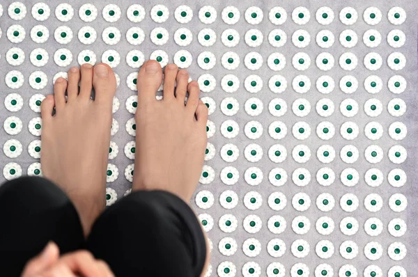 Female feet on acupressure mat. Alternative medicine  and home-massage concept