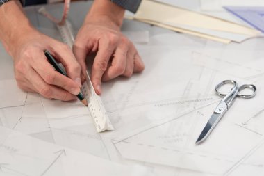 İş sırasında dikiş desenleri olan profesyonel bir terzi. Moda tasarımı konsepti.