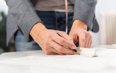 İş sırasında dikiş desenleri olan profesyonel bir terzi. Moda tasarımı konsepti.