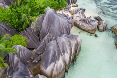 Tropikal kıyı şeridi ve mavi okyanus kayaları. Seyşel Adaları