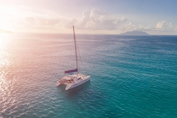 One sailboat in the ocean at sunset. Summertime yachting concept.