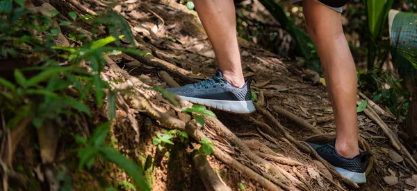 Man hiking, close up legs with sports shoes shot.