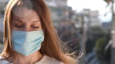 Tek kullanımlık cerrahi maske takan genç bir kadının görüntüsü. Covid-19 pandemik koruma kavramı.