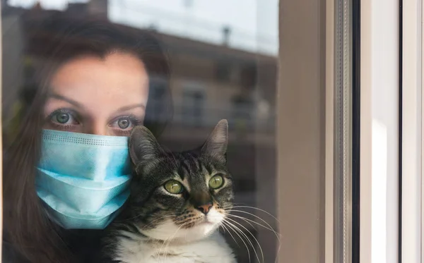 Orvosi Maszkos Macskát Tart Szomorúan Néz Ablakon Macskájával Kezében Karantén — Stock Fotó