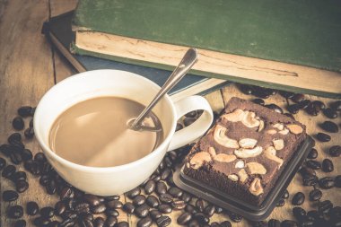 Eski ahşap arka planda kahve fincanı ve kahve çekirdeği. 