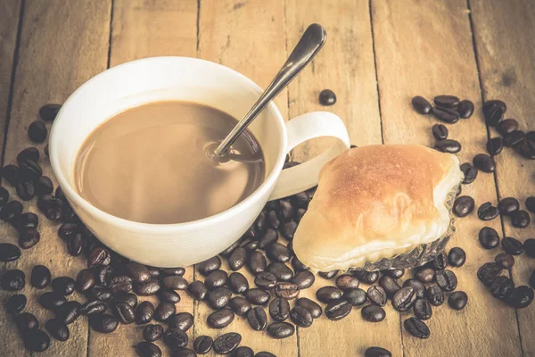 Coffee cup and coffee beans on old wooden background — Stock Photo, Image