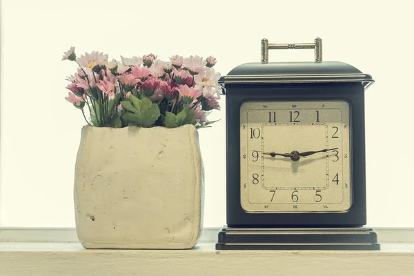 Relógio de alarme retro com um vaso de flores no interior — Fotografia de Stock