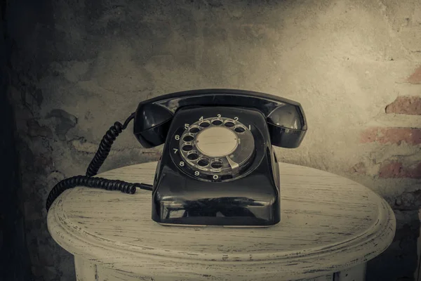 Вінтажний чорний телефон на фоні старих стін — стокове фото