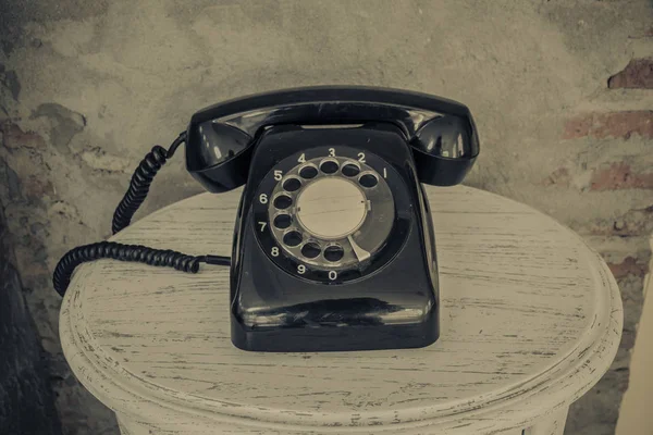Vintage telepon hitam di latar belakang dinding lama — Stok Foto