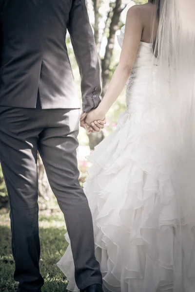 Motyw ślubny, trzymanie się za ręce nowożeńców — Zdjęcie stockowe