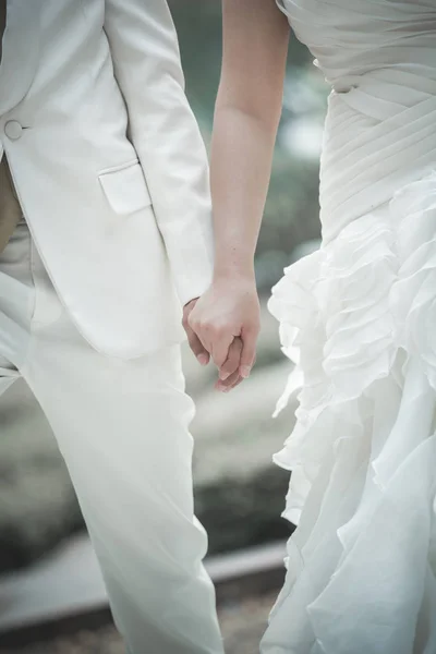 Ręce nowożeńców, którzy złapać symbol miłości — Zdjęcie stockowe