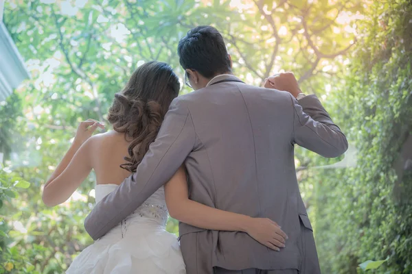 Recién casados en un hermoso vestido de novia contra el telón de fondo de t — Foto de Stock